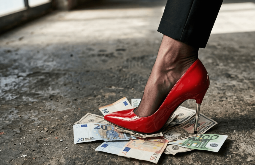 Salto alto vermelho pisando sobre notas de euro e dólar no chão